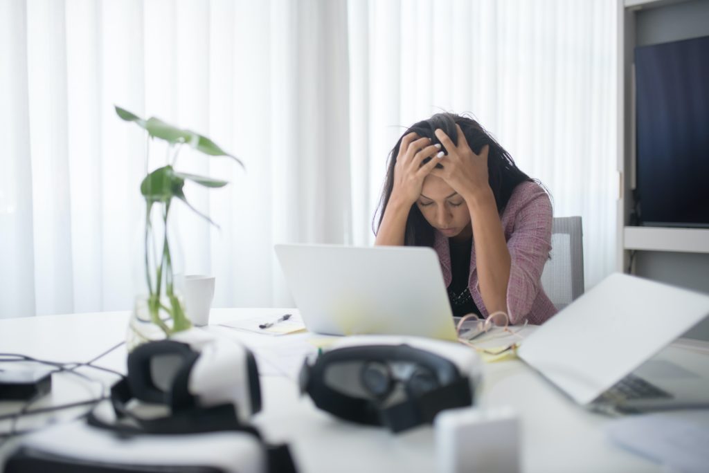 A photo of a woman stressed at her work desk for the article titled: A Journey to Building an Imperfect Practice